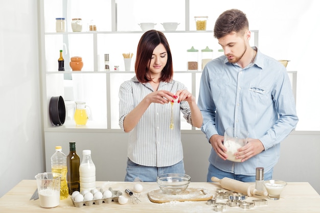 Casal feliz apaixonado cozinhando massa na cozinha