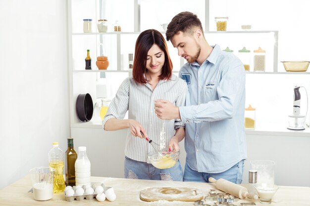 Casal feliz apaixonado cozinhando massa na cozinha