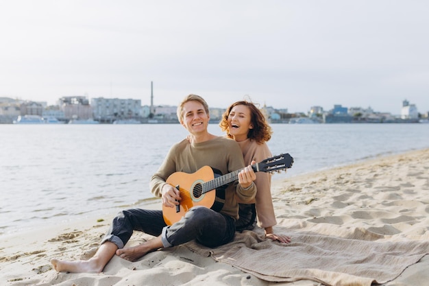 Casal feliz apaixonado Retrato sensual deslumbrante de um jovem casal Jovem tocando violão para sua amada