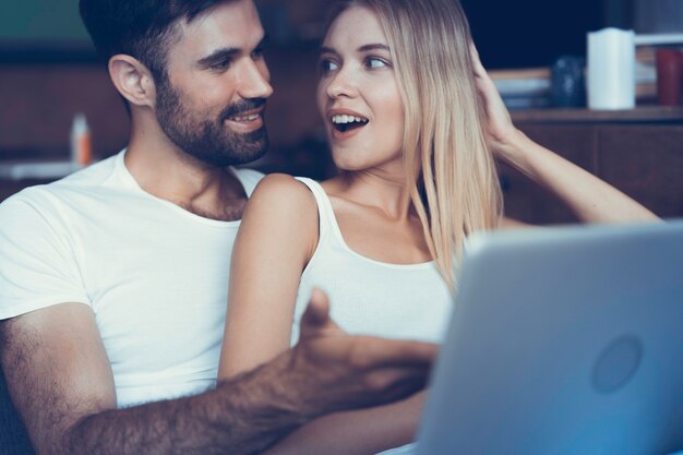 Casal feliz apaixonado surfando no tablet em casa.