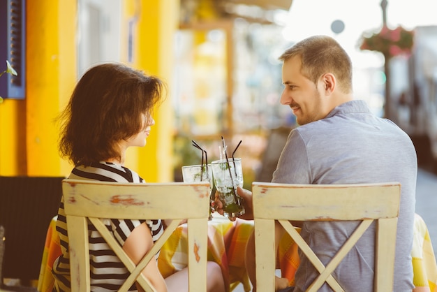 Foto casal feliz bebendo limonada em um café do lado de fora.