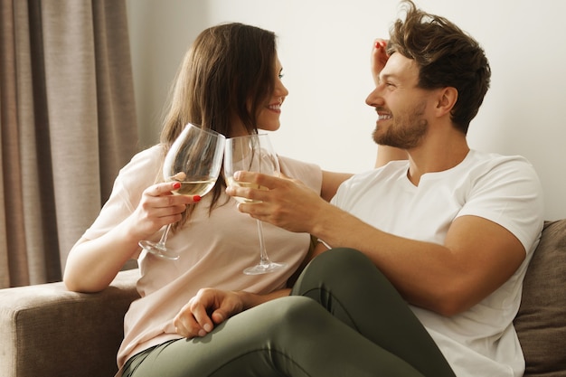 Casal feliz bebendo vinho e relaxando em casa