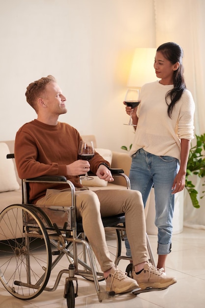 Casal feliz bebendo vinho em casa