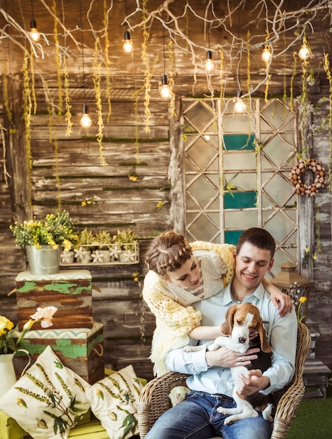 Casal feliz brincando com seu amado cachorro na sala de estar