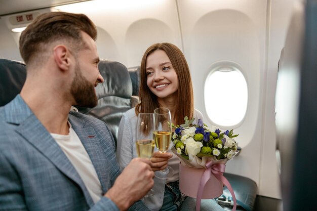 Casal feliz brindando com champanhe no avião