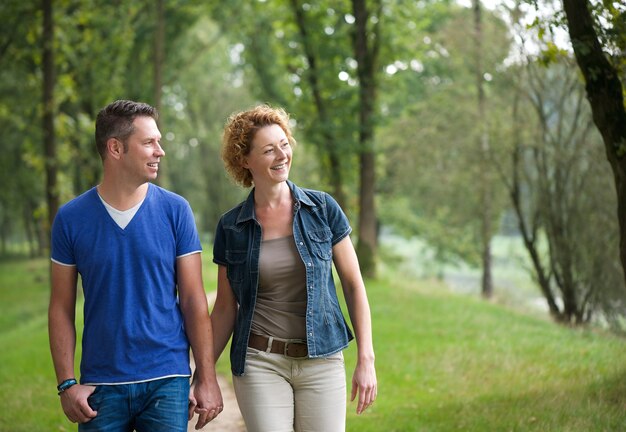 Casal feliz caminhando juntos ao ar livre