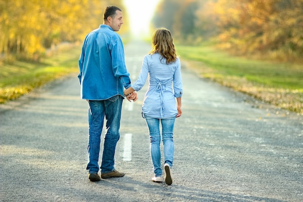 Casal feliz caminhando na estrada na natureza no parque viaja