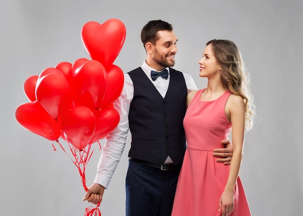 casal feliz com balões em forma de coração vermelho