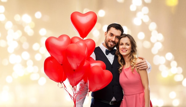 casal feliz com balões em forma de coração vermelho