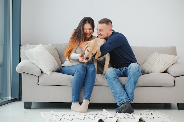 Casal feliz com cachorro na sala de estar