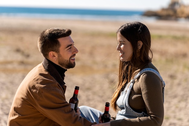 Casal feliz com cerveja na praia