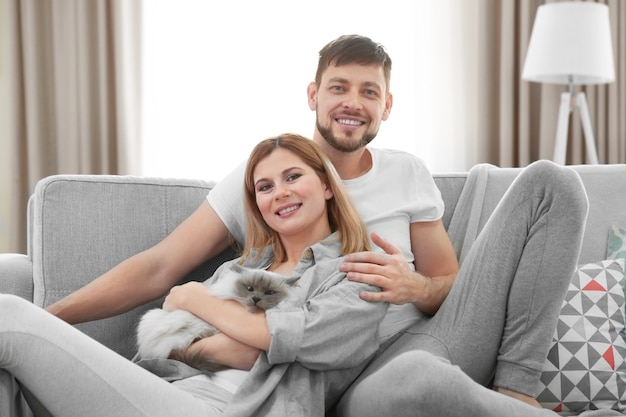 Casal feliz com gato em casa