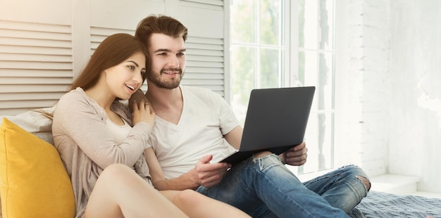 Casal feliz com laptop na manhã de fim de semana