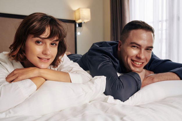 Casal feliz com pijama descansando na cama