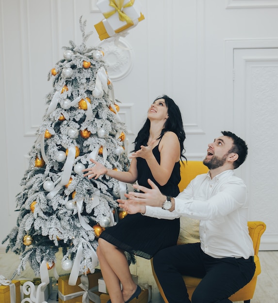 Casal feliz com presente de Natal isolado sobre fundo de luzes