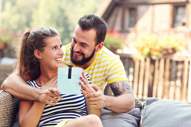 Casal feliz com presente sentado ao ar livre