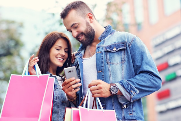 casal feliz com sacolas de compras depois de fazer compras na cidade