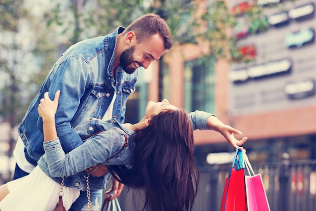 Casal feliz com sacolas de compras depois de fazer compras na cidade