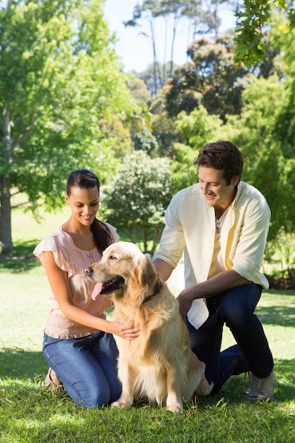 Casal feliz com seu cão de estimação no parque