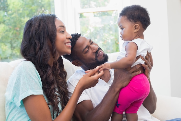 Casal feliz com sua menina no sofá