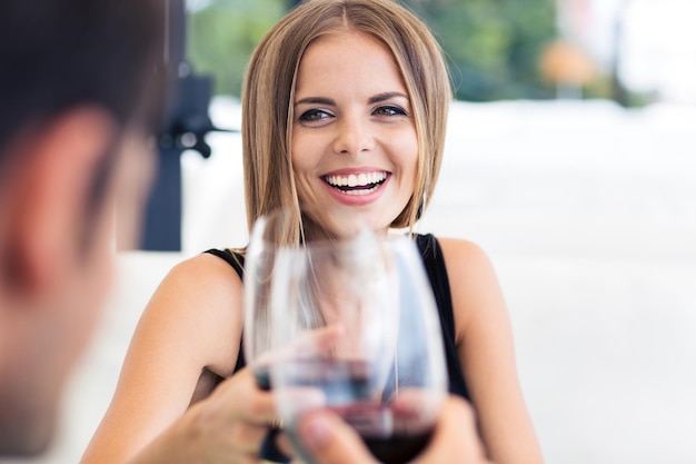 Casal feliz comemorando algo em restaurante com vinho tinto