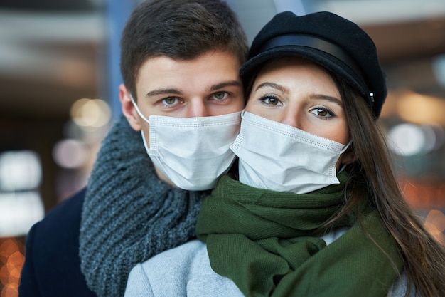 Casal feliz comemorando o Dia dos Namorados com máscaras durante a pandemia covid-19 na cidade