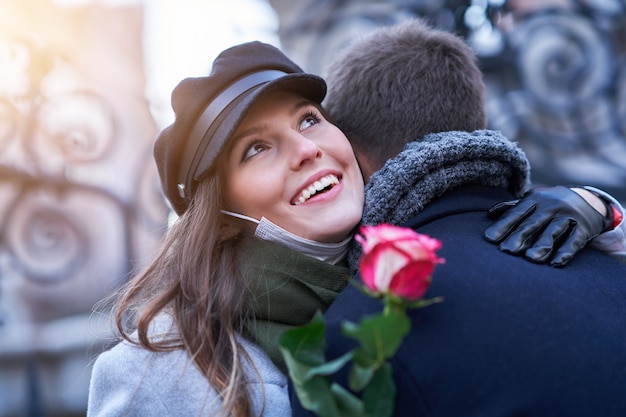 Casal feliz comemorando o Dia dos Namorados com máscaras durante a pandemia covid-19 na cidade