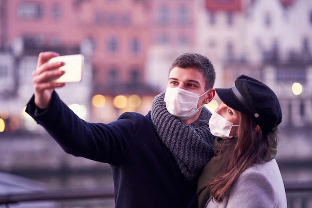 Casal feliz comemorando o Dia dos Namorados com máscaras durante a pandemia covid-19 na cidade