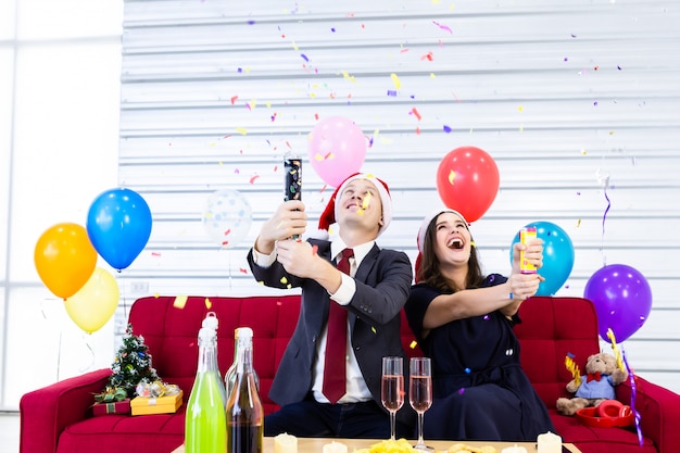 Casal feliz comemorando o Natal com uma festa com balões