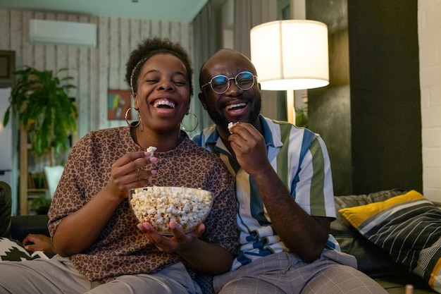 Casal feliz comendo a pipoca juntos