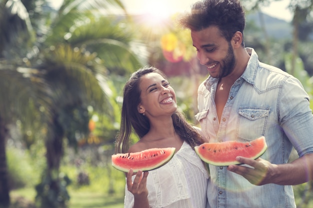 Casal feliz comendo melancia juntos alegre