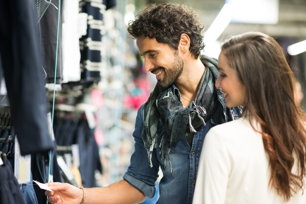 Casal feliz compras em uma loja de roupas