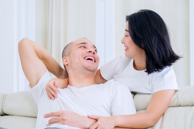 Casal feliz conversando juntos no sofá