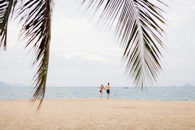 Casal feliz corre na praia Vista para o mar e praia de areia na Ásia Vietnã