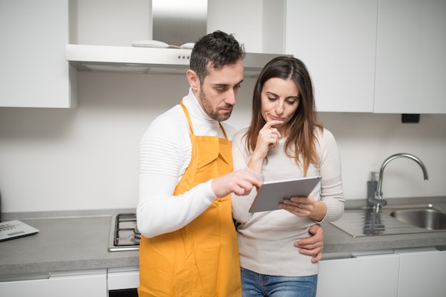 Casal feliz cozinhando em sua cozinha