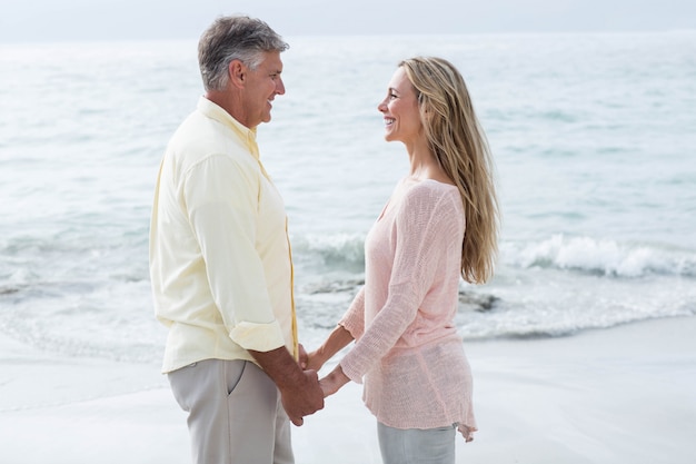 Casal feliz de mãos dadas e a sorrir para o outro