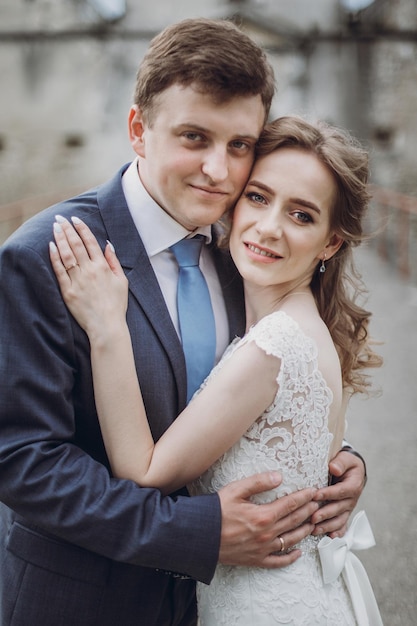 Casal feliz de recém-casados posando perto do momento do casamento de conto de fadas do castelo linda noiva e noivo abraçam perto da entrada do antigo castelo na Europa