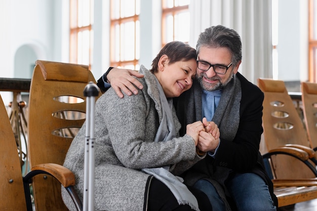 Casal feliz de tiro médio sentados juntos