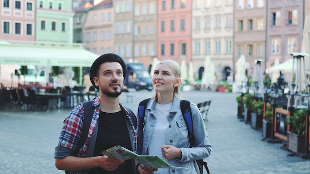 Casal feliz de turistas procurando nas principais atrações turísticas usando o mapa. eles estão tão felizes em ir passear.