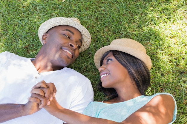 Casal feliz deitado no jardim juntos na grama