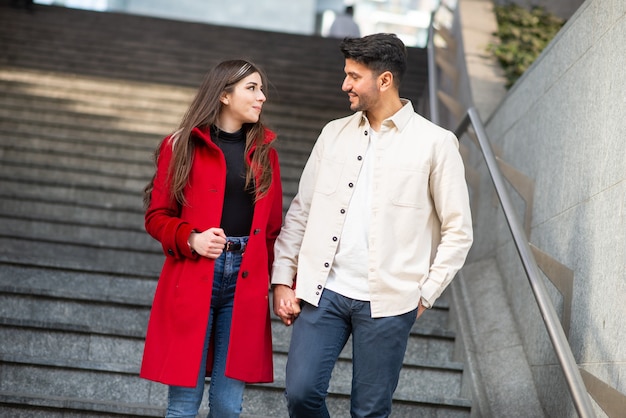 Casal feliz descendo uma escada juntos