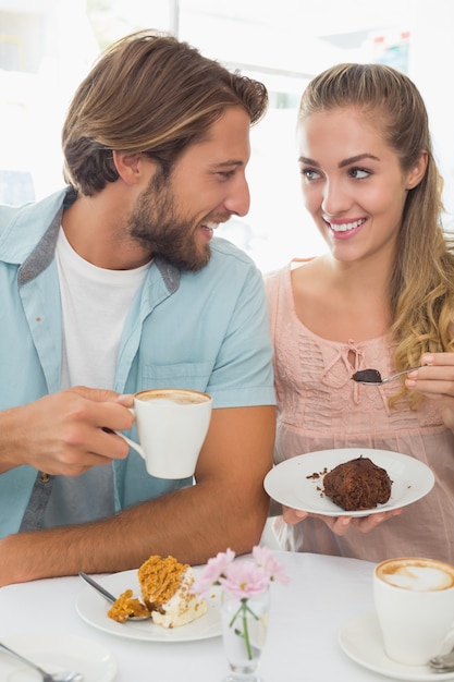 Casal feliz desfrutando café e bolo