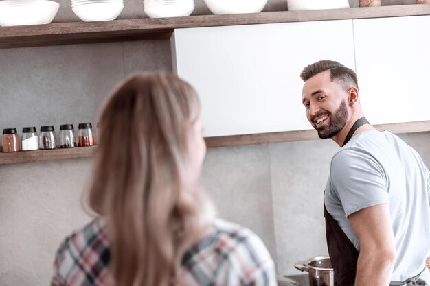 Casal feliz discutindo o menu em pé na cozinha