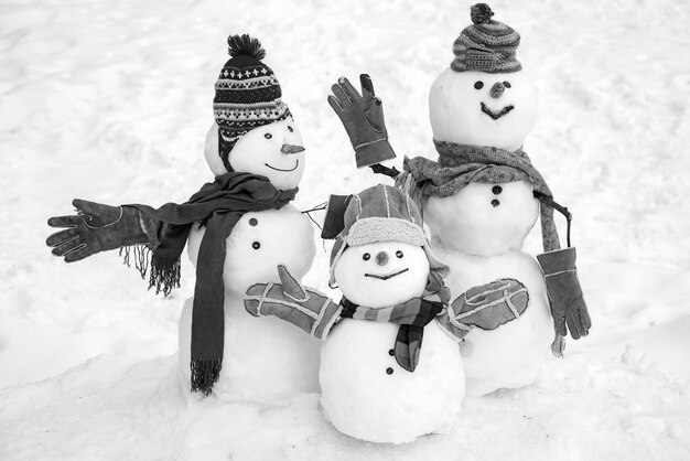 Casal feliz do boneco de neve e criança do boneco de neve com o presente de Natal no inverno.