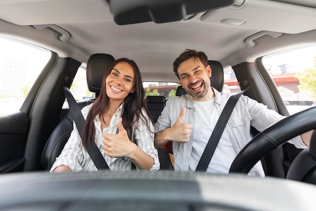 Casal feliz do milênio mostrando mais cinco sentado no carro