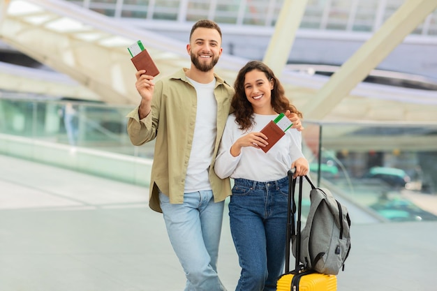 Foto casal feliz e amoroso abraçando-se no terminal do aeroporto enquanto esperavam o voo