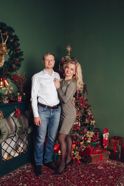 Casal feliz e apaixonado comemora ano novo juntos e sorri para a foto na atmosfera de Natal