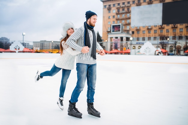 Casal feliz e apaixonado posa na pista de patinação