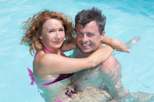 Casal feliz e atraente curtindo férias na piscina