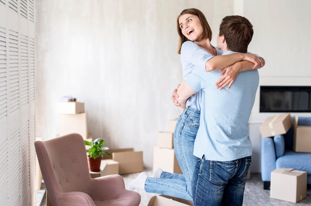 Foto casal feliz em casa se abraçando no dia da mudança